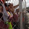 Panama Canal workers look on from behind a fence as strike enters day number 2