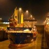 Conatainer ship is illuminated as it passes through the Panama Canal at night.