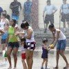 A Panamanian family cools off in the water spray along the Cinta Costera during the second day of Carnival 2012 in Panama